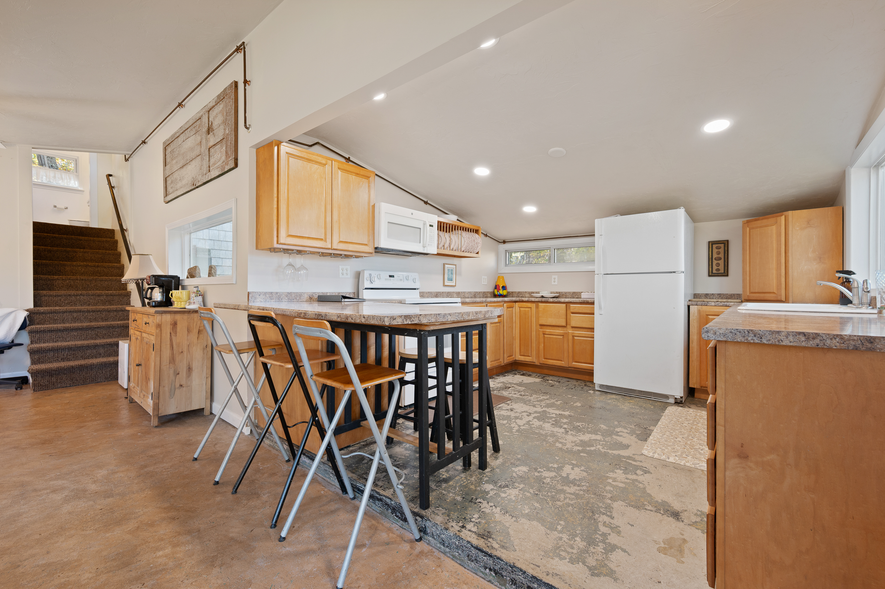 Cozy kitchen with wooden cabinets and a rustic dining table with folding chairs.