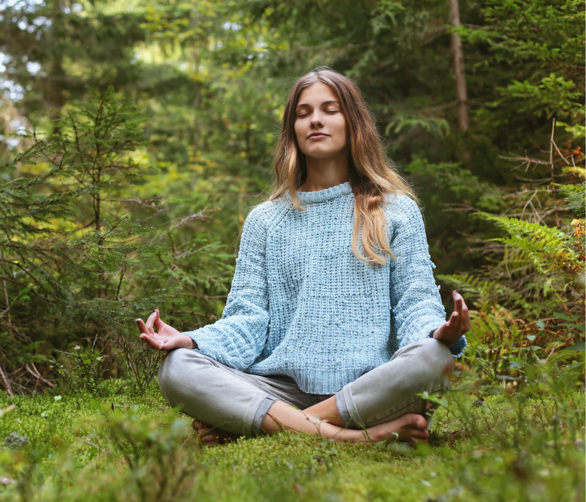 Woman meditating in a forest