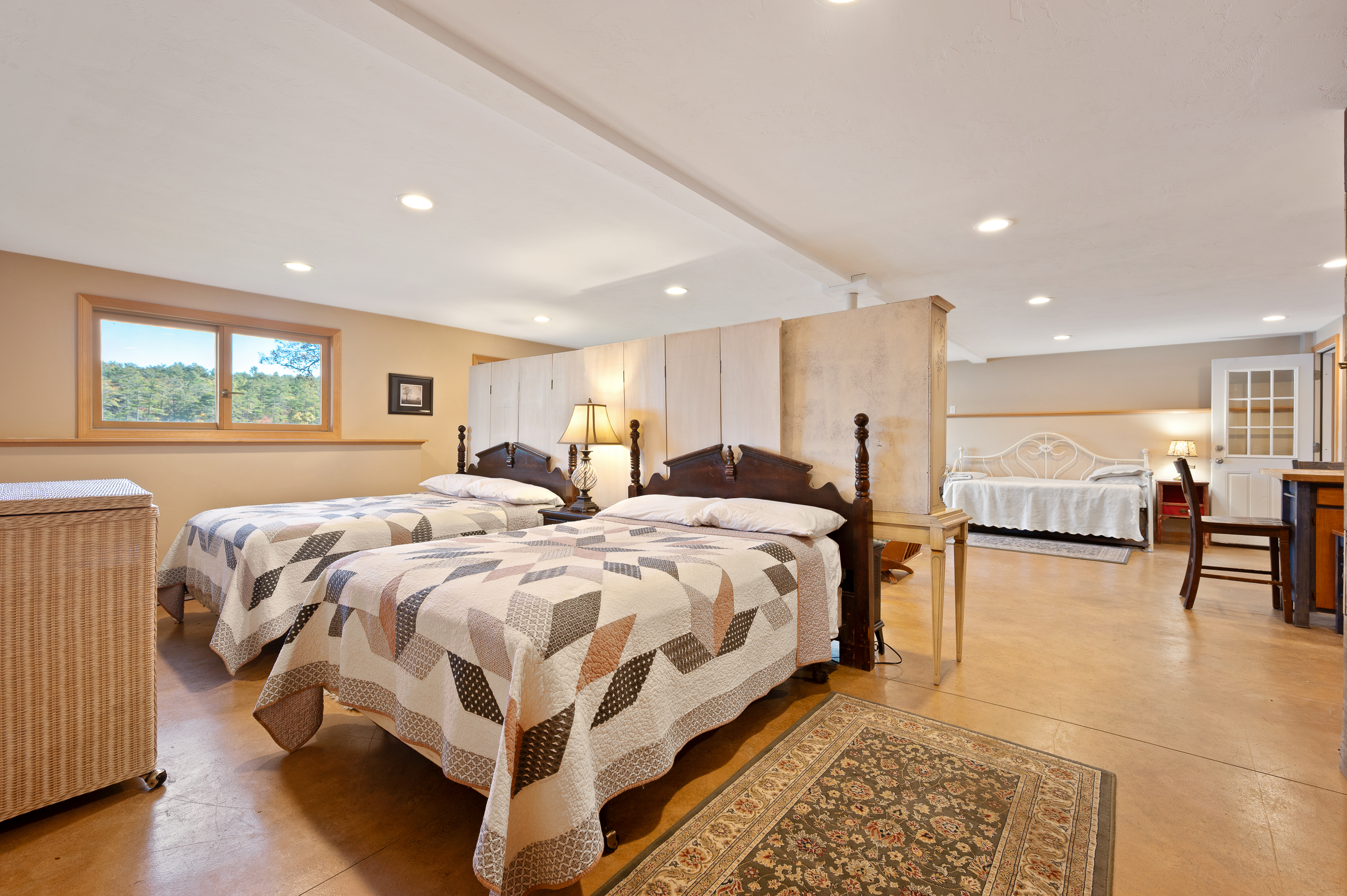 Spacious bedroom with twin beds and warm lighting.