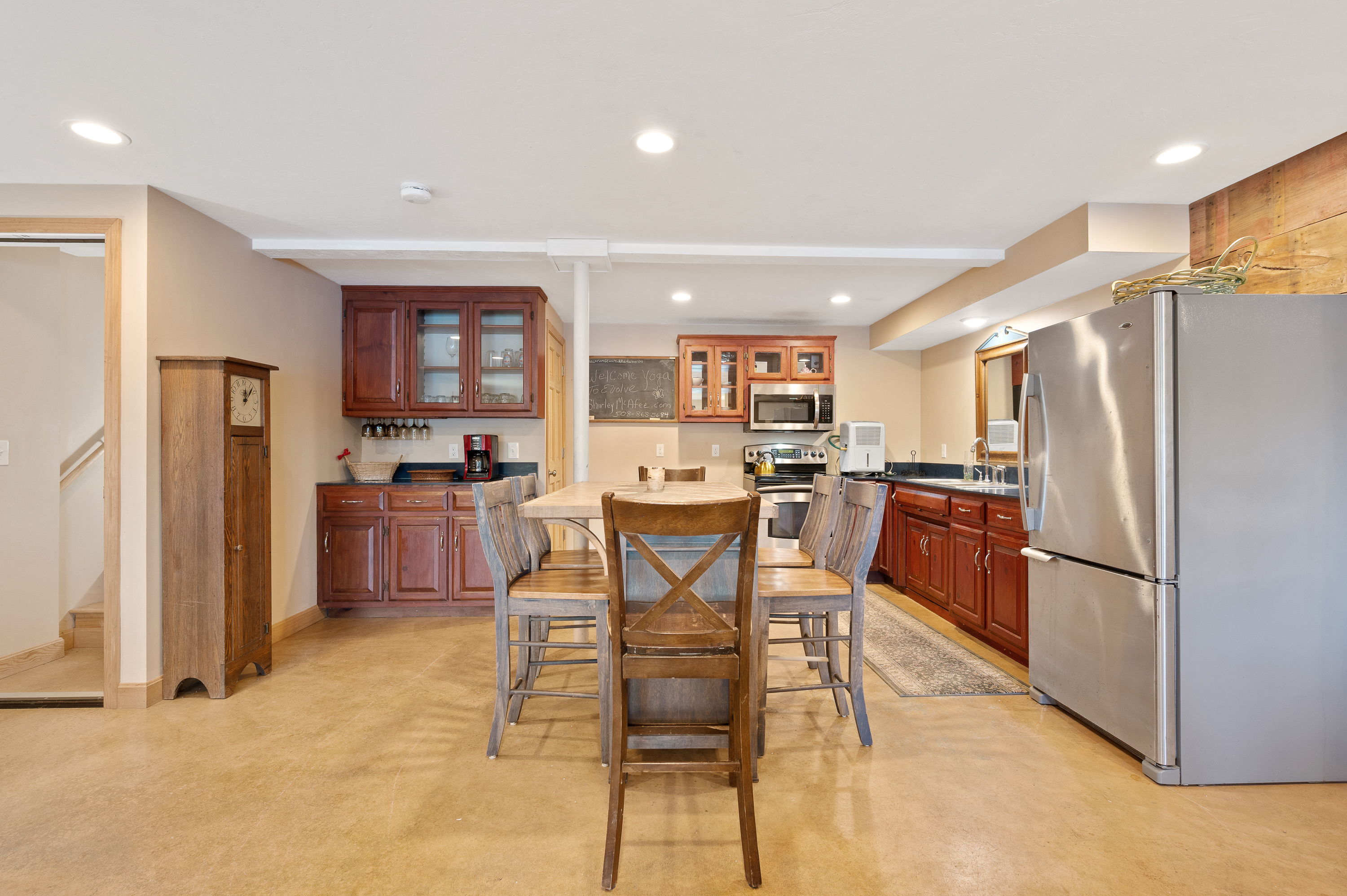 Cozy kitchen with wooden cabinets, stainless steel appliances, and a central island with chairs.